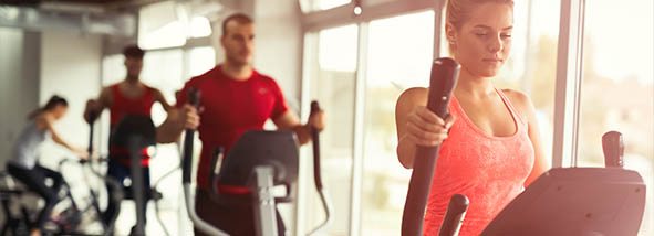 fitness members working out in cardio section of gym