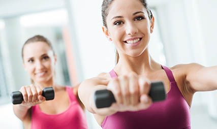 Sporty girls weightlifting at fitness gym