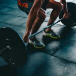 A person performing compound lifts during a full body exercises routine