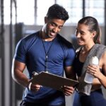 Qualified fitness instructor assessing client movement and posture during initial onboarding